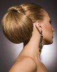 Stile raccolto con styling liscio e uno chignon esagerato