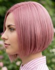 Capelli rosa in un bob corto e asimmetrico